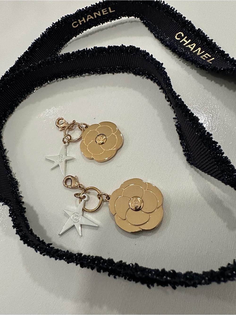 CHANEL Gold Camellia & Silver Star Charm Pair with Black Ribbon